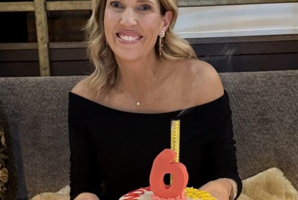 Leah Phillips was diagnosed with stage IV EGFR NSCLC in 2019 at 43 years old. She is celebrating her 6 years of survival with a cake in front of her while she is smiling.