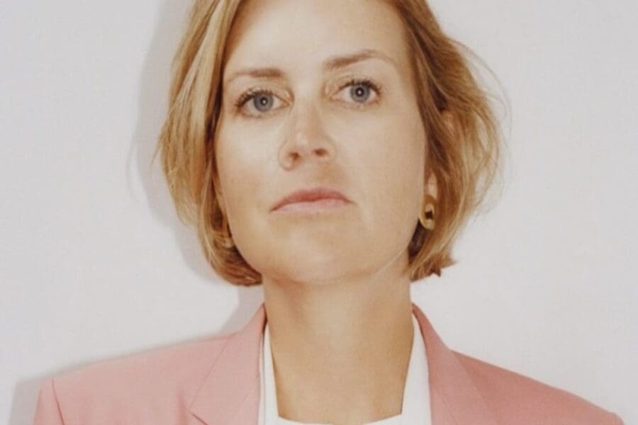 Jessie Creel was diagnosed in 2024 with stage IV EGFR NSCLC. She was 42 years old and had 3 young children. Jessie is a well know producer and director. She is wearing a white shirt and pink jacket with blond hair.