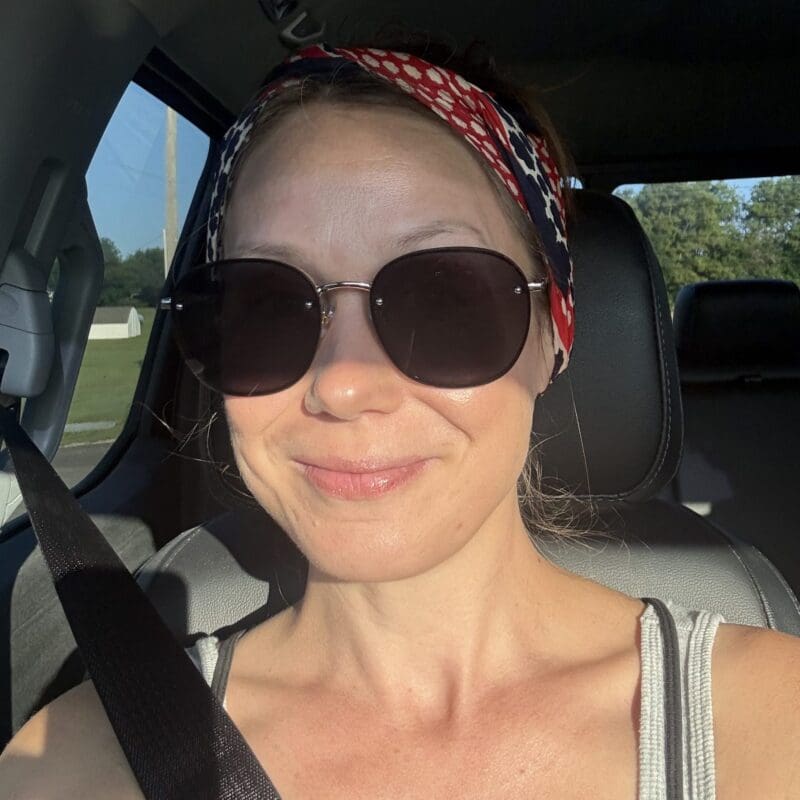 Rachel, a lung cancer patient from Kansas, smiles wearing sunglasses.