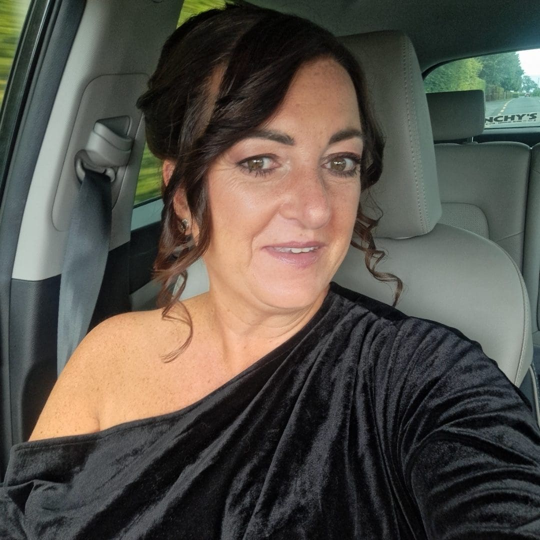 Samantha V, an Irish young lung cancer survivor diagnosed at 47, wearing a one shoulder black top.