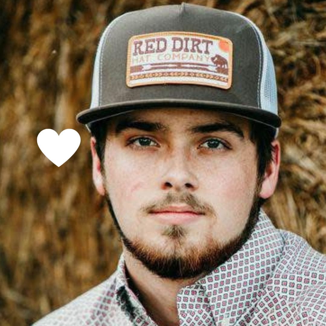 Trevor, a young man with lung cancer from Kentucky, smiles in a trucker hat.