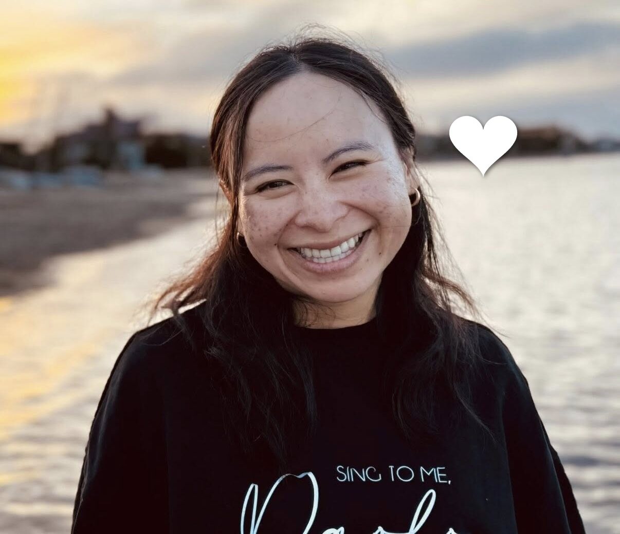 Anna, a young woman with lung cancer, smiles on the beach. In loving memory.