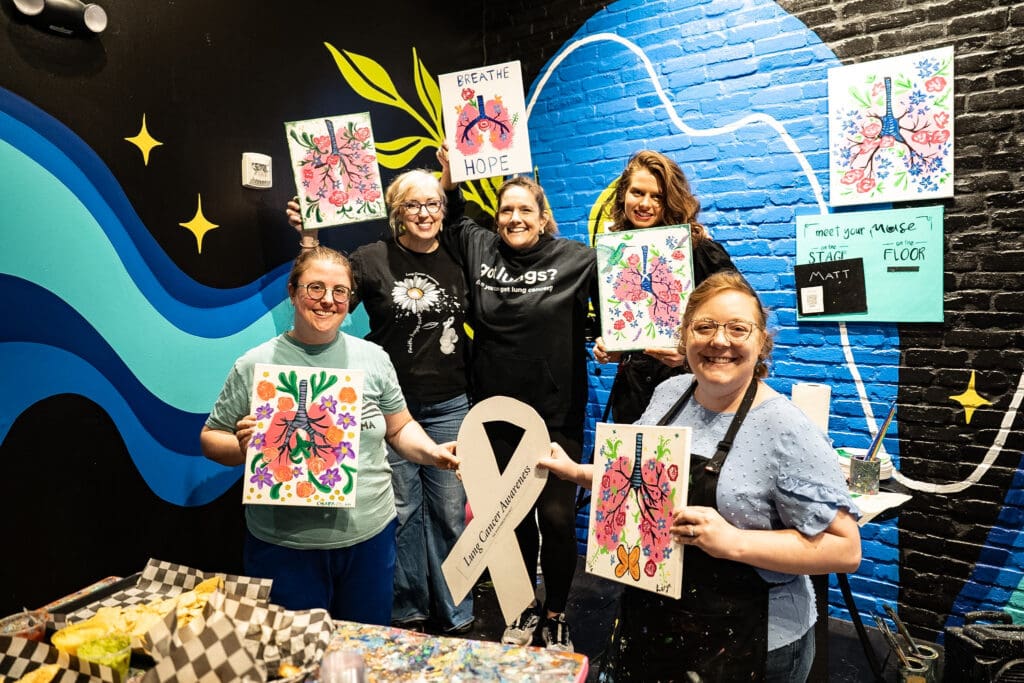 Young lung cancer community holds up canvas lung paintings YLCI get together