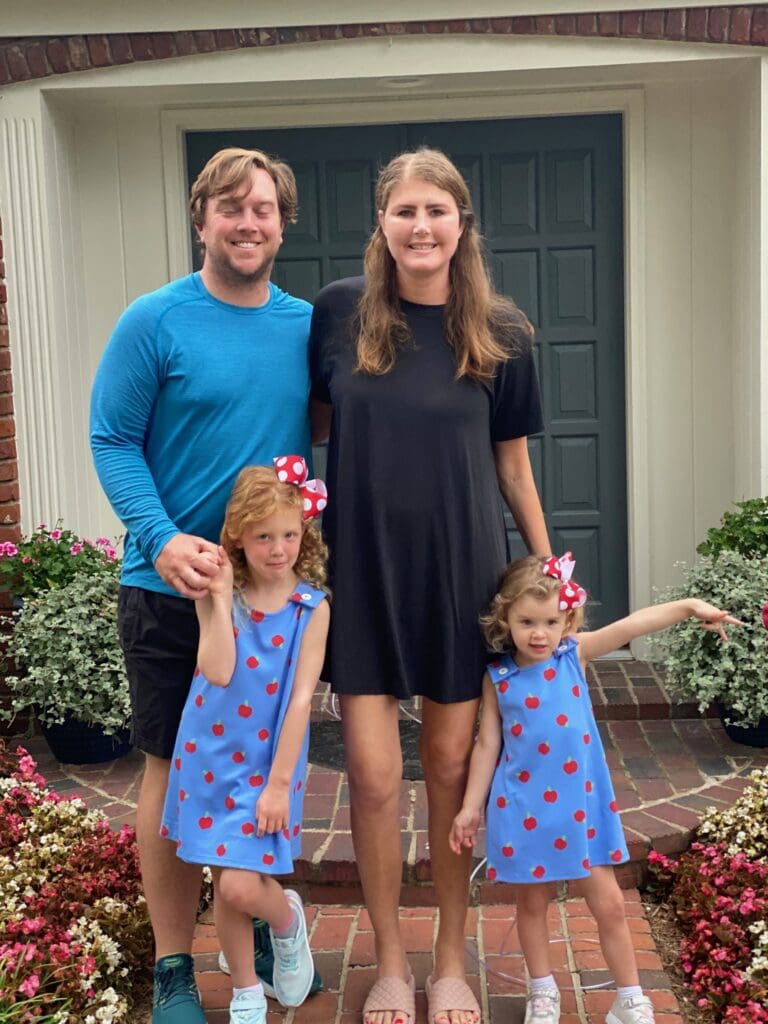 Elizabeth with her husband and two young children outdoors