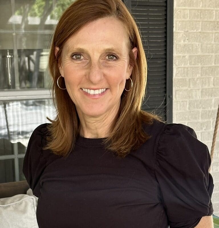 Ilana, a patient with RET+ lung cancer, smiles outdoors on a porch.