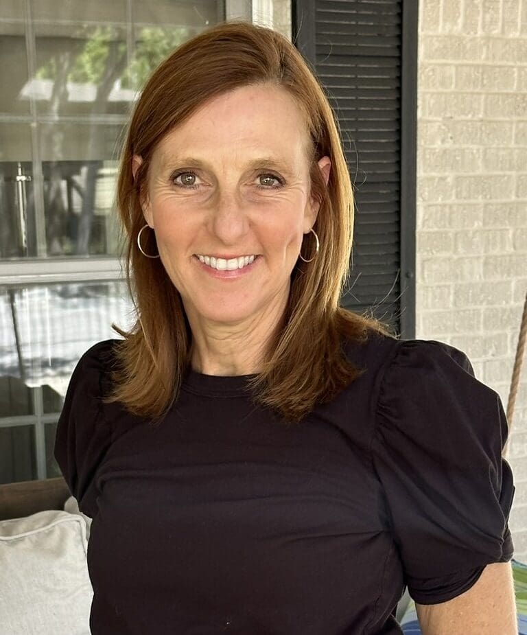 Ilana, a patient with RET+ lung cancer, smiles outdoors on a porch.