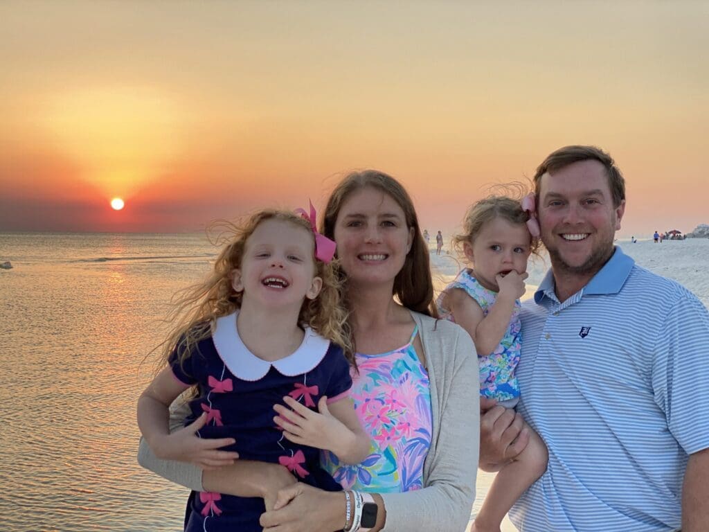 Elizabeth and her family on the beach during a sunset