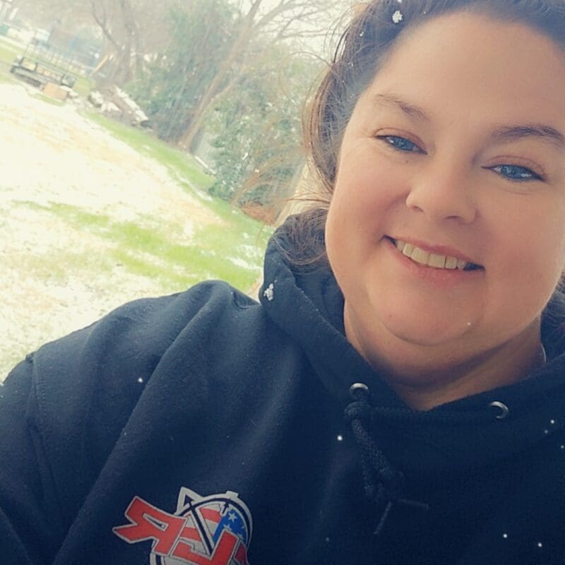 Sarah, a young woman with lung cancer from Texas, smiling in the snow.