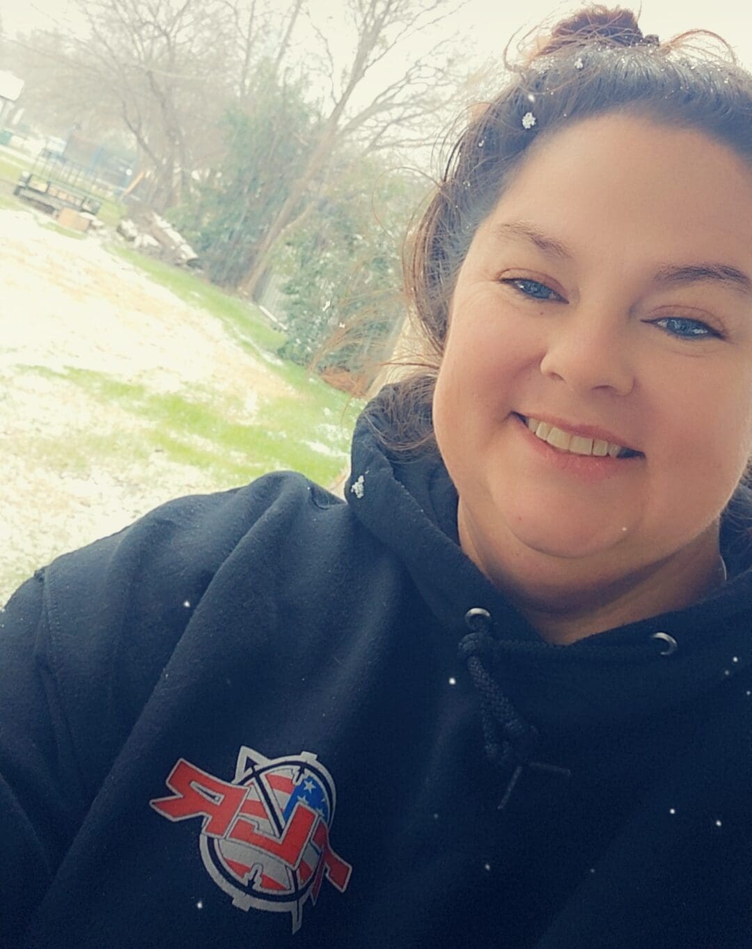 Sarah, a young woman with lung cancer from Texas, smiling in the snow.