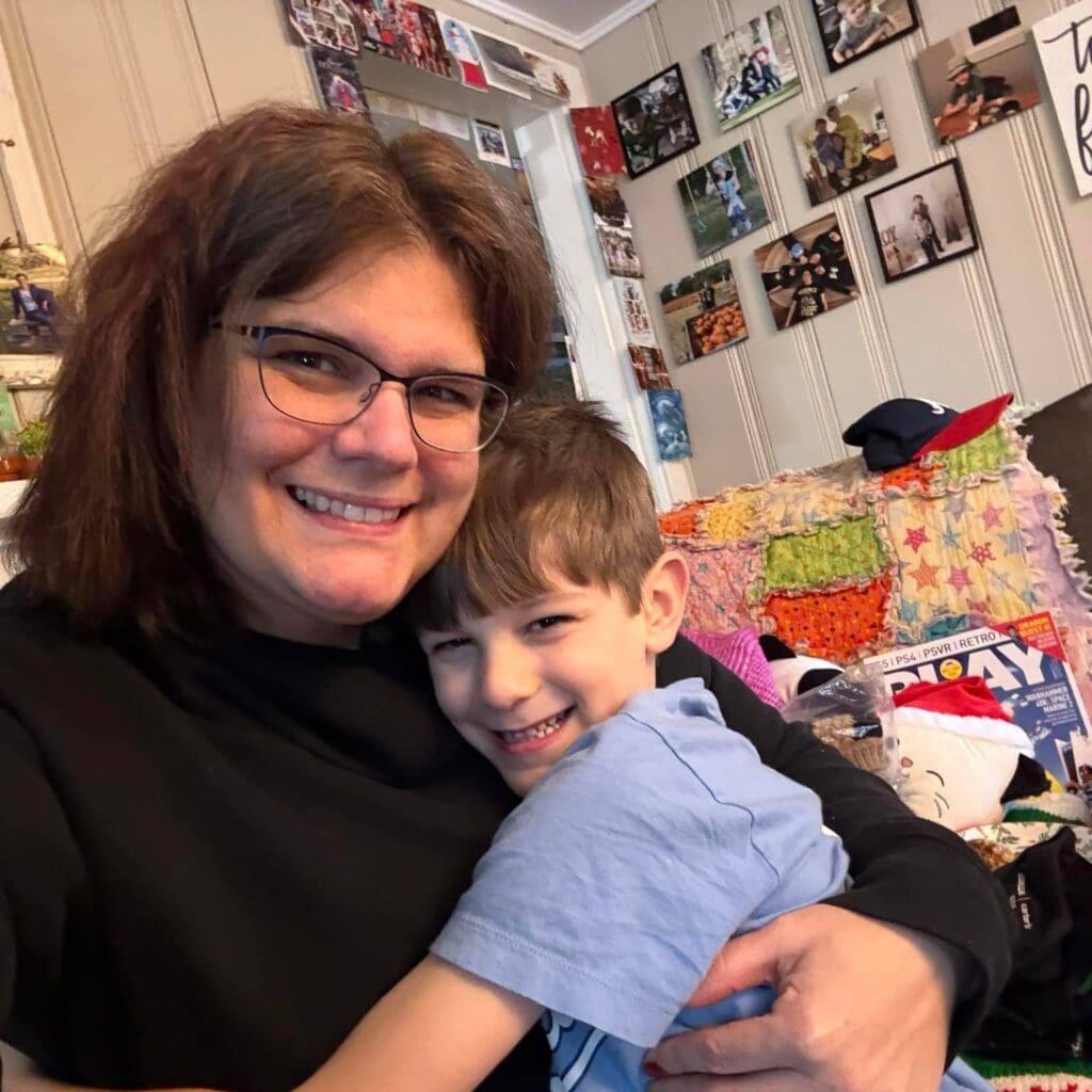 Theresa, a young lung cancer patient, smiling while hugging a young boy