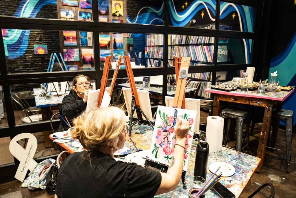 Young lung cancer patients painting at easels during the YLCI Boston meet-up