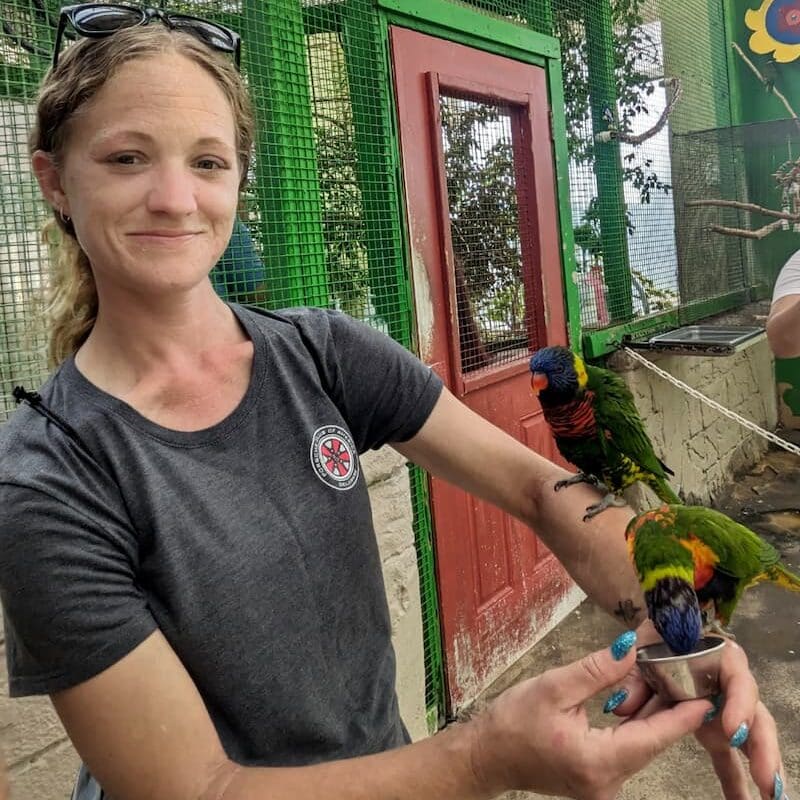 Brittany, a young patient with lung cancer, poses with a bird on her arm