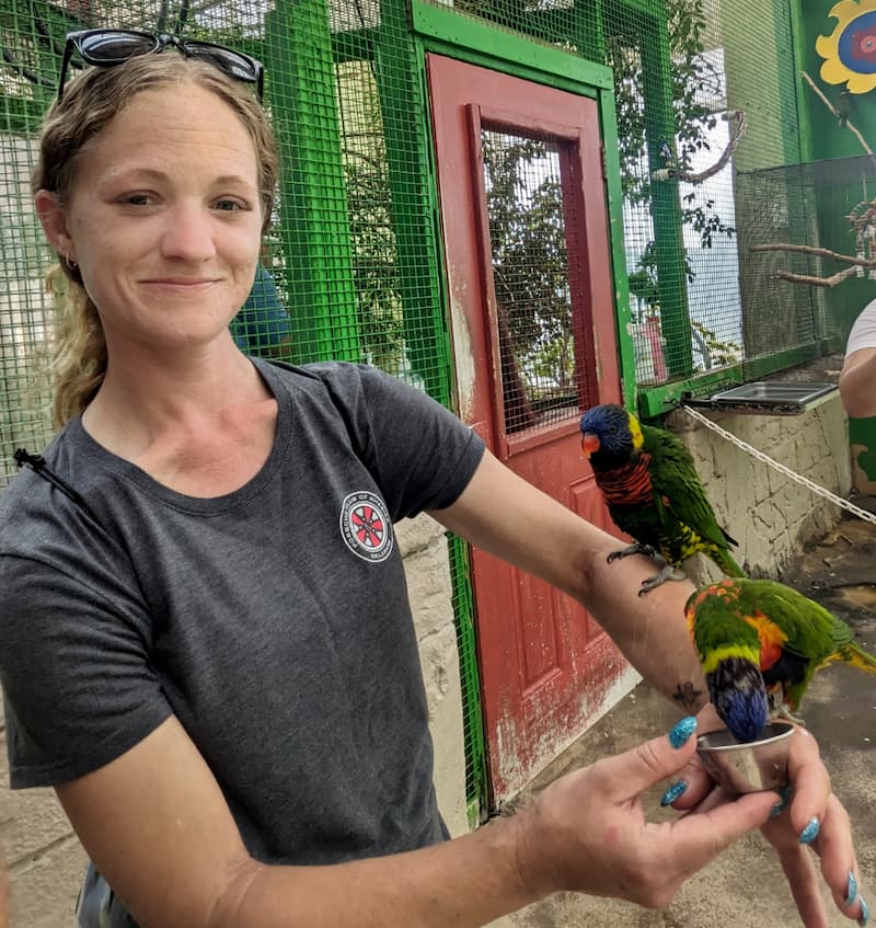 Brittany, a young patient with lung cancer, poses with a bird on her arm