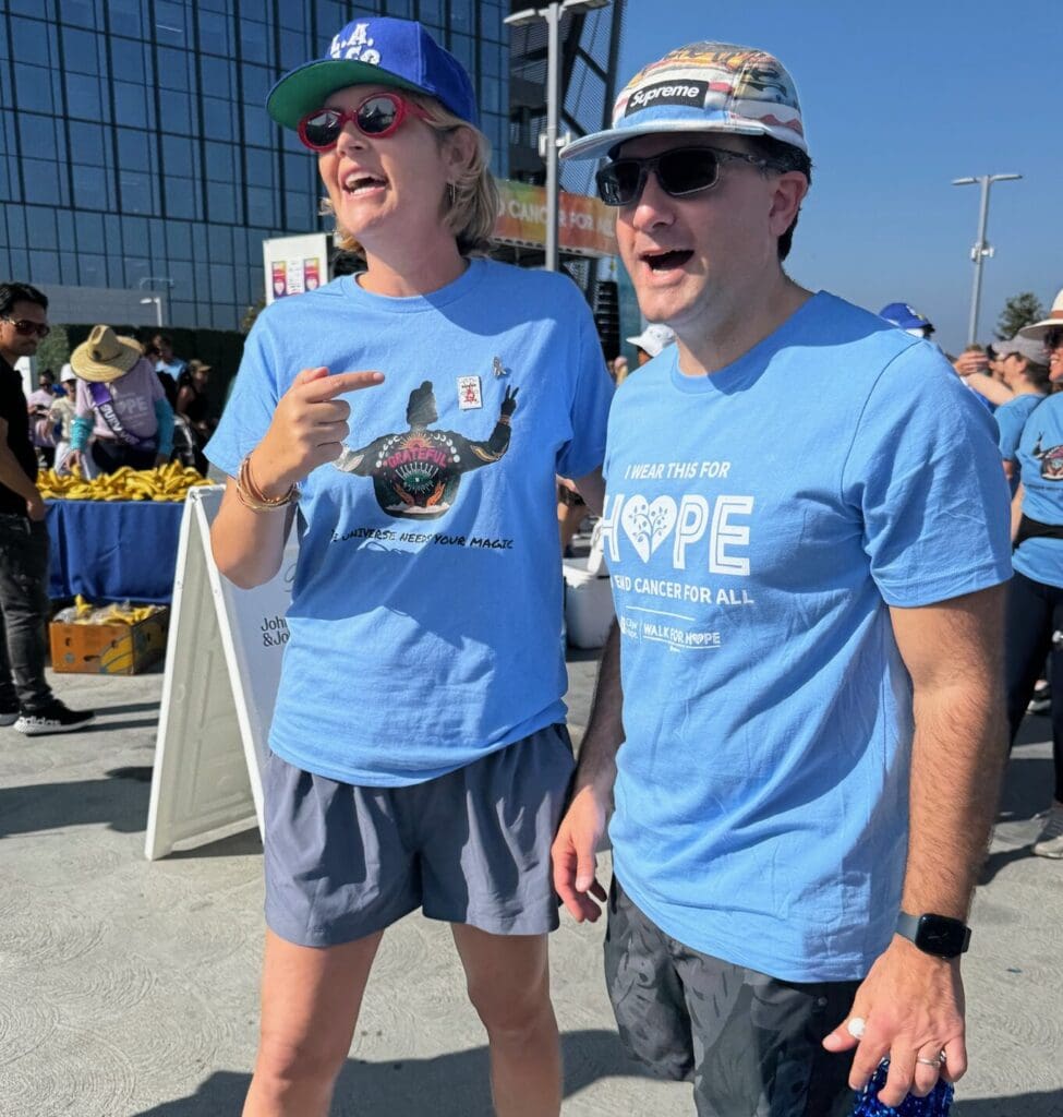 Jessie Creel and friend in matching blue Hope t-shirts at the City of Hope walk, one holding blue pom-pom