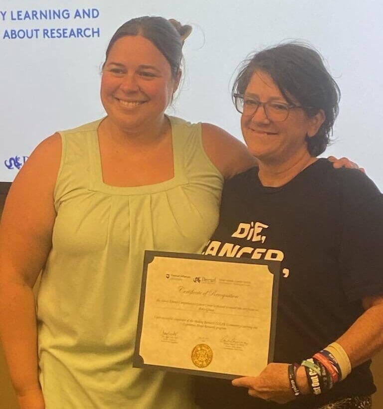 Lung cancer patient advocate Amy Grove smiling and holding her Certificate of Recognition