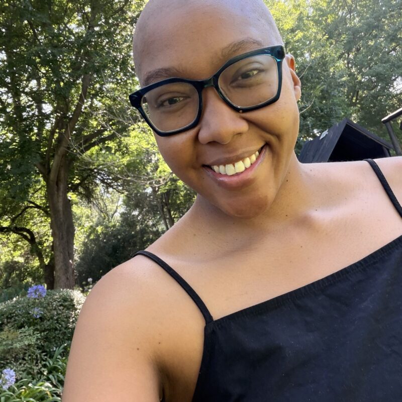 Young lung cancer patient, Cassidy Leslie, smiling out doors. From South Africa