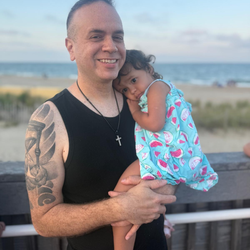 Young lung cancer patient smiles holding daughter.