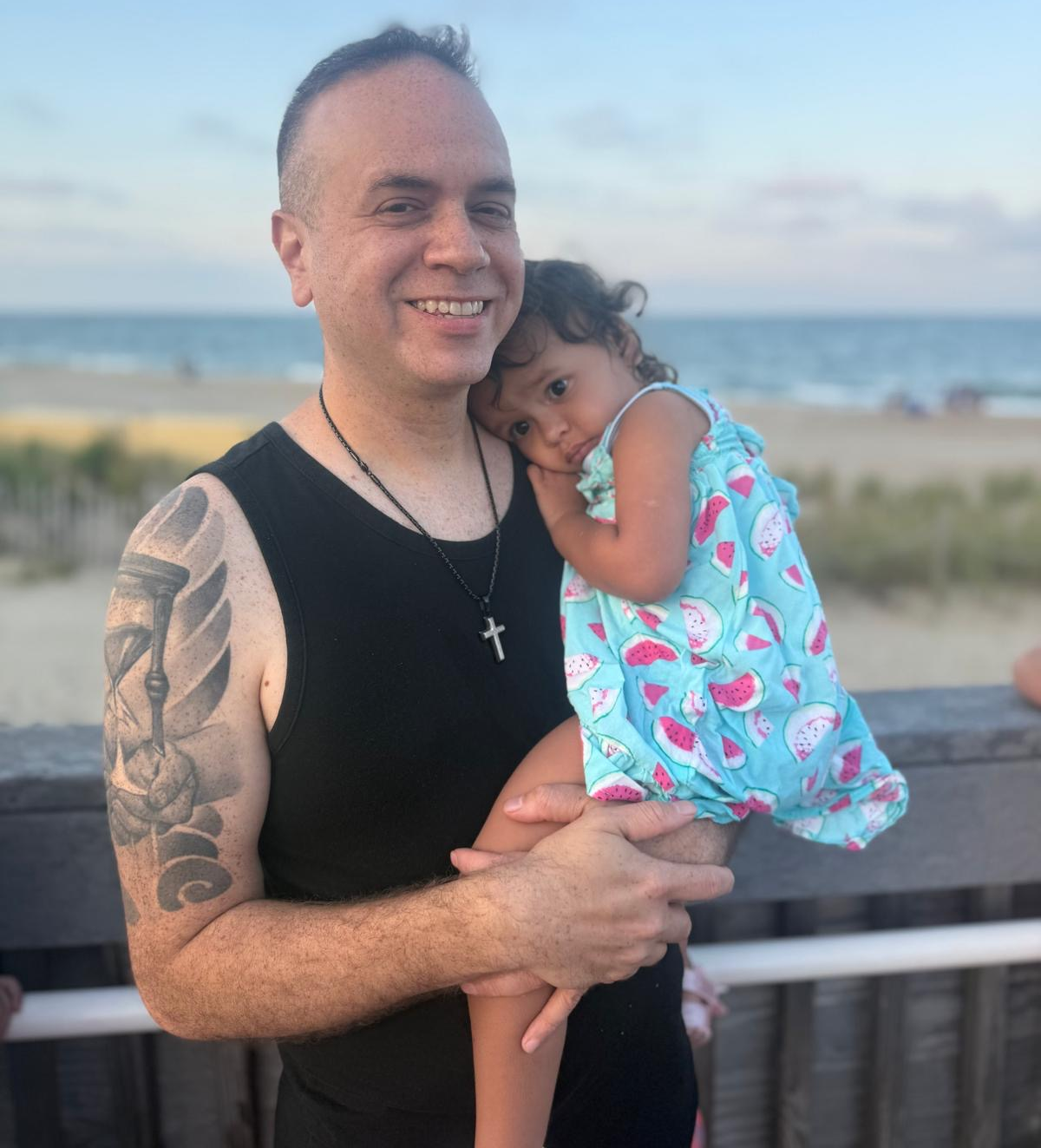 Young lung cancer patient smiles holding daughter.